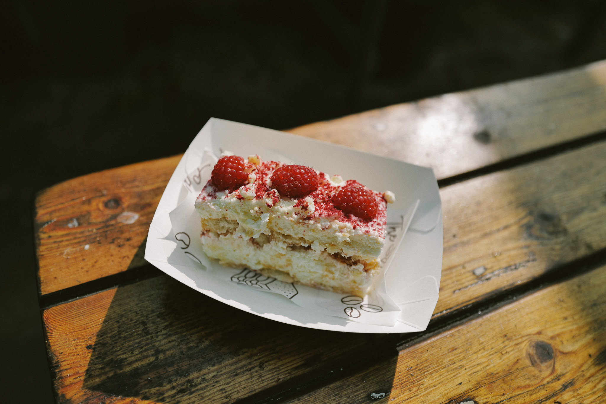 A slice of tiramisu on a sunlit café table